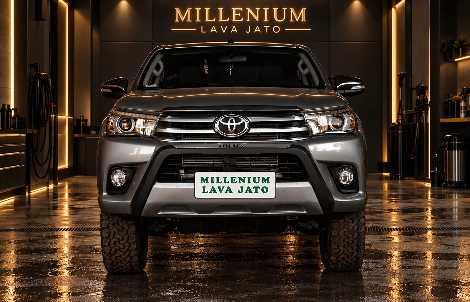 Toyota Hilux prata, de frente, em galpão escuro
